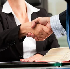 Aperto de mãos sobre contrato, representando acordo trabalhista